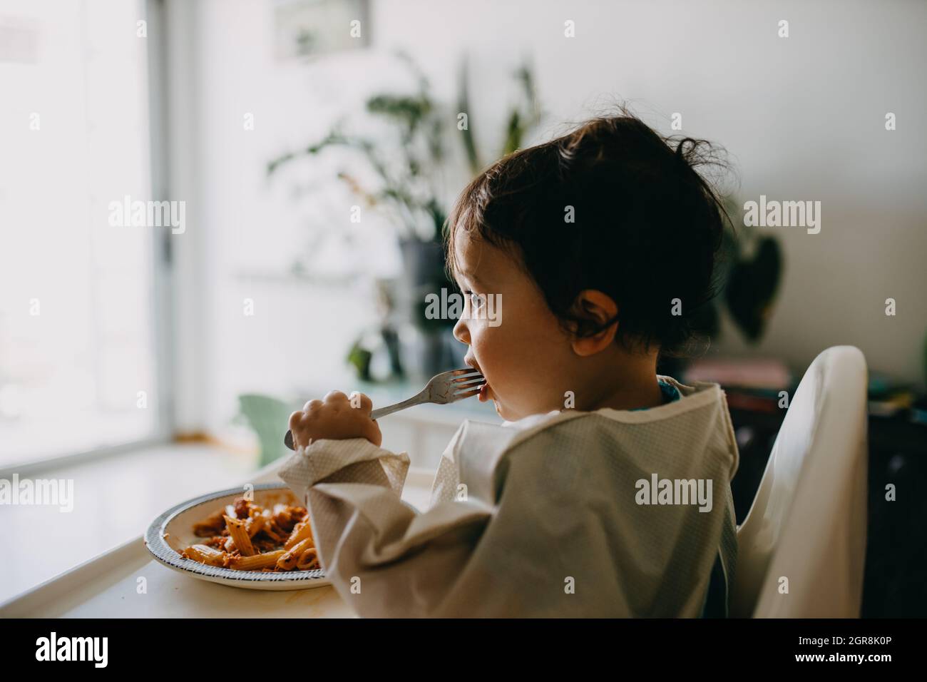 Boy Looking Away While Sitting On Table Stock Photo