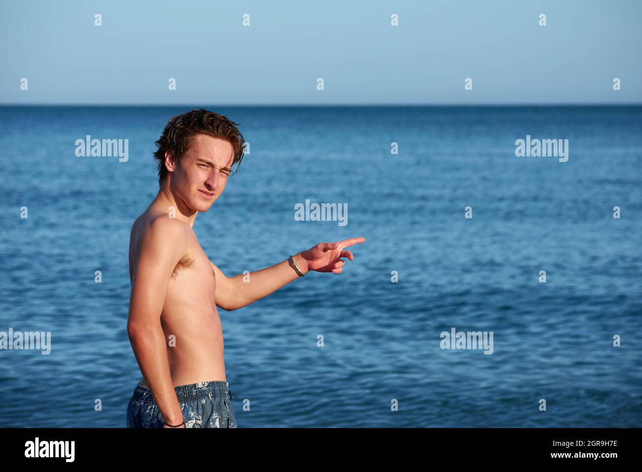 A Spanish male standing in the seawater, posing and having fun Stock Photo Alamy