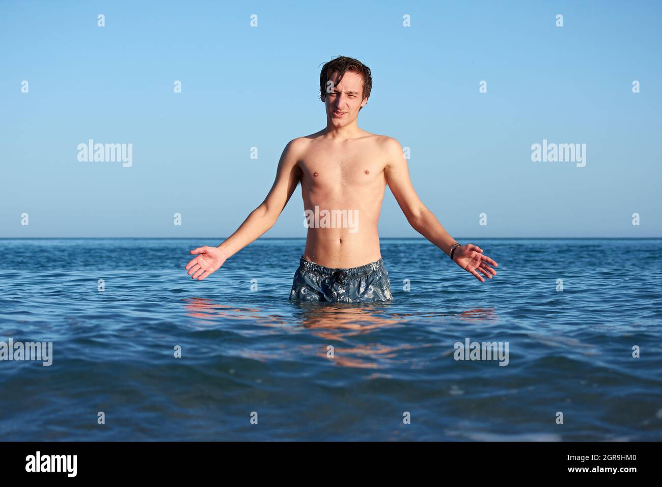 A Spanish male standing in the seawater, posing and having fun Stock Photo Alamy