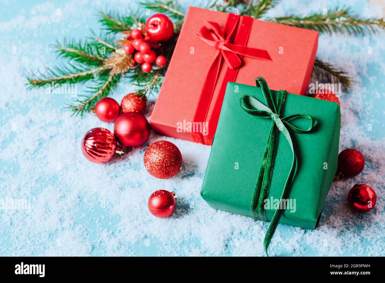 Festive boxes on a blue background with Christmas toys balls a branch of fluffy spruce sparkles confetti. New Year Christmas concept. Flat festive Stock Photo