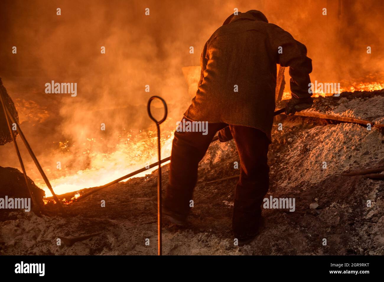 The process of releasing pig iron from a blast furnace. A man works