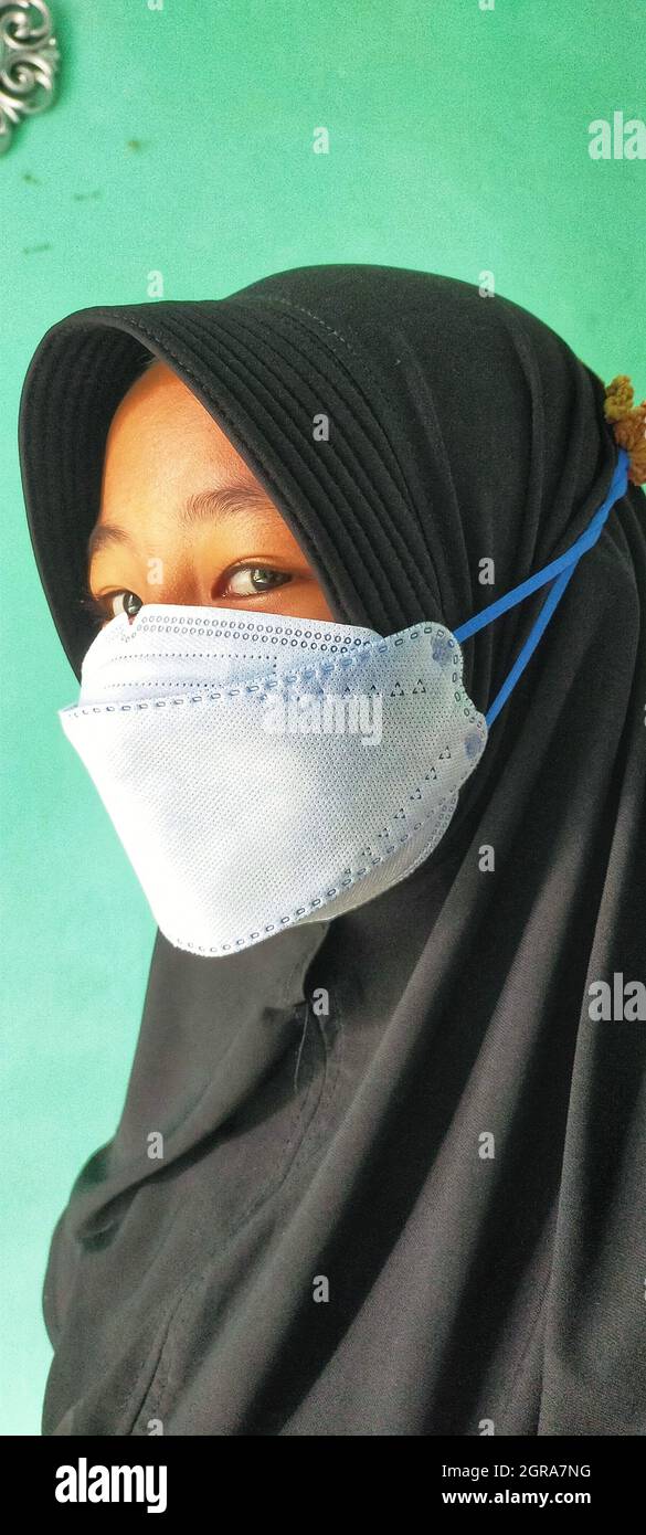 Young Muslim Girl Wearing Face Mask In New Normal Rule Stock Photo