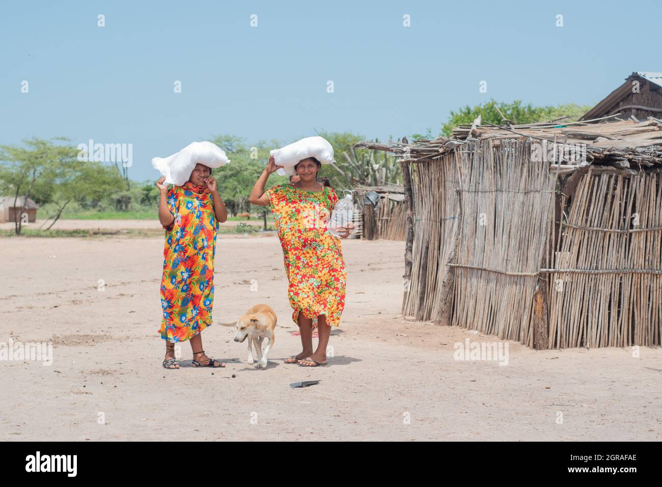 Mayapo, Colombia. 26th Sep, 2021. Women of the Wayuu indigenous community pose for a photo covering their heads from the sun during a Humanitarian Mission developed by 'De Corazon Guajira' in Mayapo at La Guajira - Colombia were they visited the Wayuu indigenous communities 'Pactalia, Poromana, Perrohuila' on September 26, 2021. The Guajira region in Colombia is the poorest region in Colombia, with its people commongly living without drinkable water, electricity and food. Credit: Long Visual Press/Alamy Live News Stock Photo
