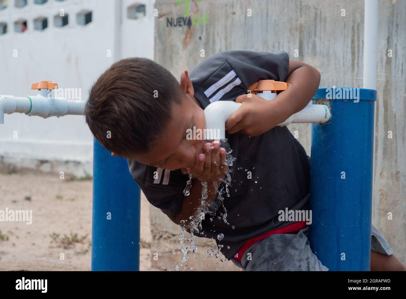 Mayapo, Colombia. 26th Sep, 2021. A kid from the Wayuu indigenous community drinks water from a pump during a Humanitarian Mission developed by 'De Corazon Guajira' in Mayapo at La Guajira - Colombia were they visited the Wayuu indigenous communities 'Pactalia, Poromana, Perrohuila' on September 26, 2021. The Guajira region in Colombia is the poorest region in Colombia, with its people commongly living without drinkable water, electricity and food. Credit: Long Visual Press/Alamy Live News Stock Photo