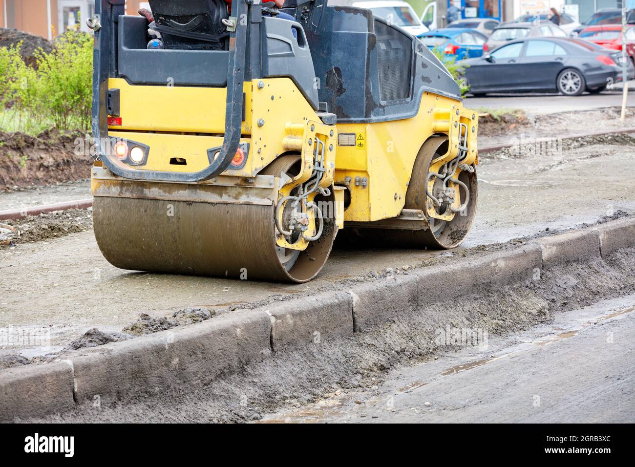 A Yellow Road Roller Tamping The Foundation Of A Sidewalk At A Construction  Site Stock Photo - Alamy