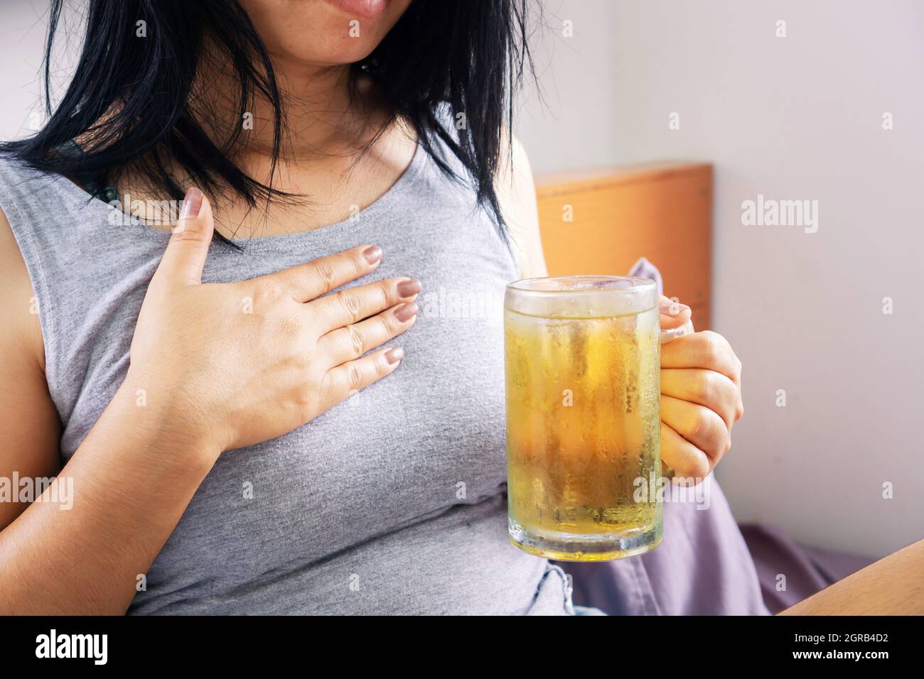Asian Woman Having Problem With Gerd , Acid Reflux, After Drinking Beer