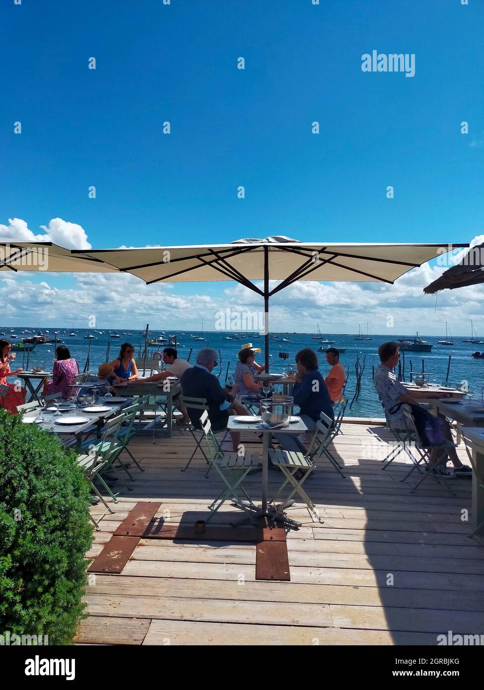 People At Restaurant With View On Sea Against Clear Blue Sky In Cap Ferret  In France Stock Photo - Alamy