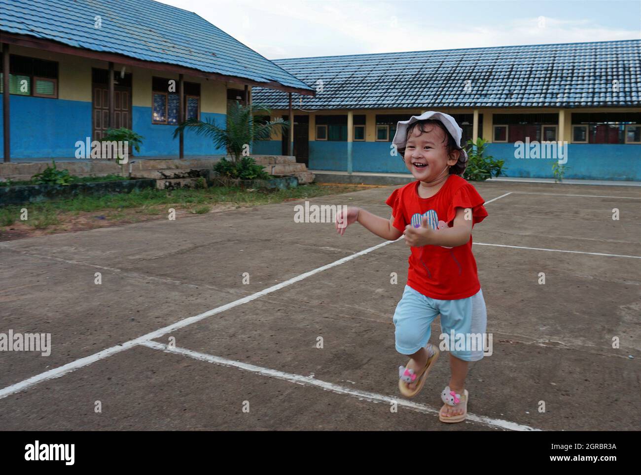 A Girl In A Red Dress Running Happily Stock Photo Alamy