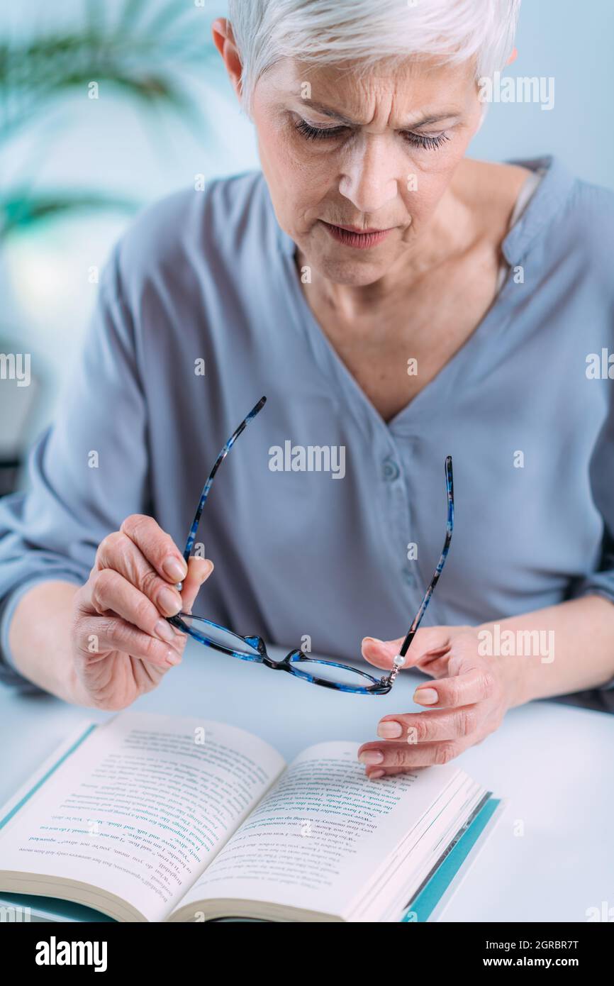 Senior Woman A Reading Book. Vision Loss Problems Stock Photo Alamy