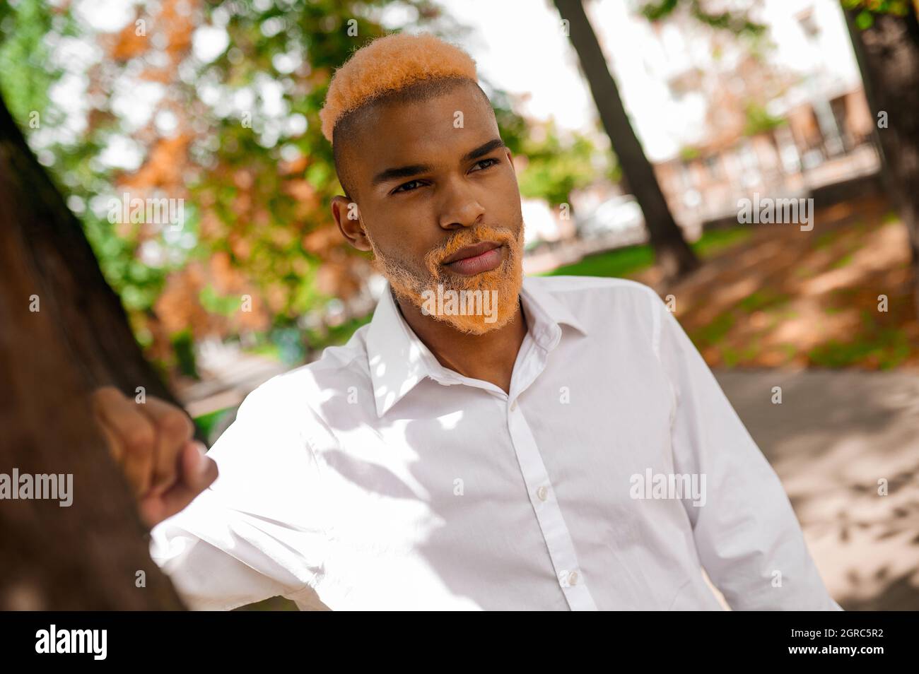A man in white clothes in the park looking serious Stock Photo