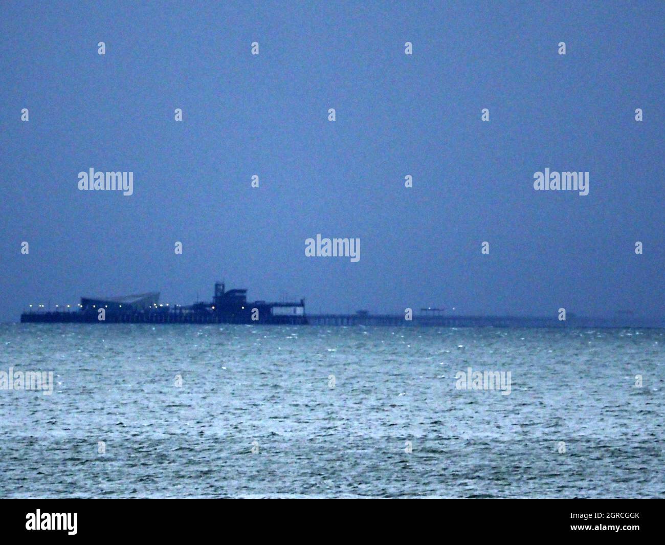 Sheerness, Kent, UK. 1st October, 2021. UK Weather: dark grey rain clouds on the first day of October in Sheerness, Kent. The end of Southend's 1 mile long pleasure pier about to disappear beneath a rain shower. Credit: James Bell/Alamy Live News Stock Photo