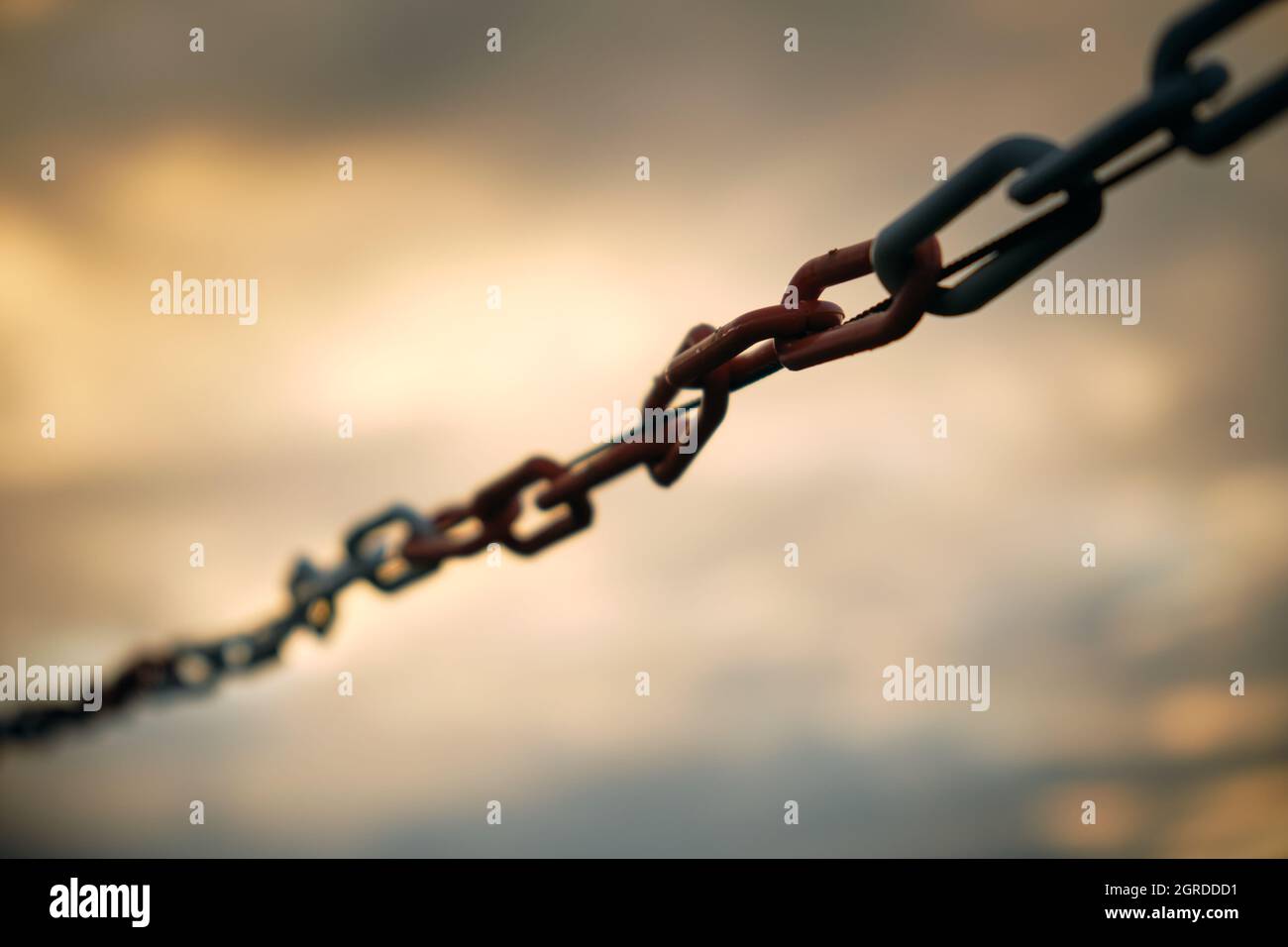 Moody close-up of plastic chain barrier against sunset sky. Seen in Germany in October Stock Photo