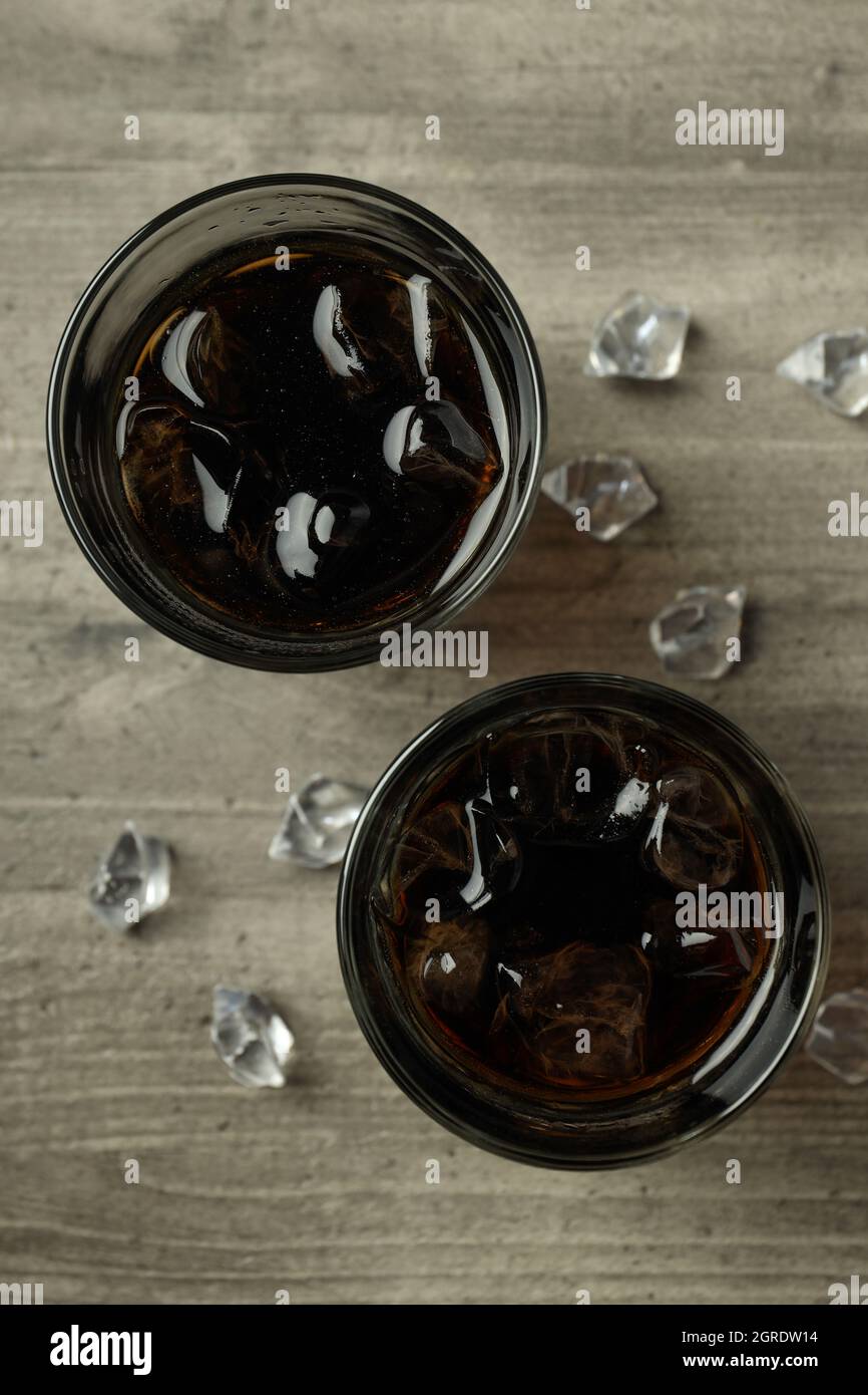 Glass of cola and ice on gray textured table Stock Photo - Alamy