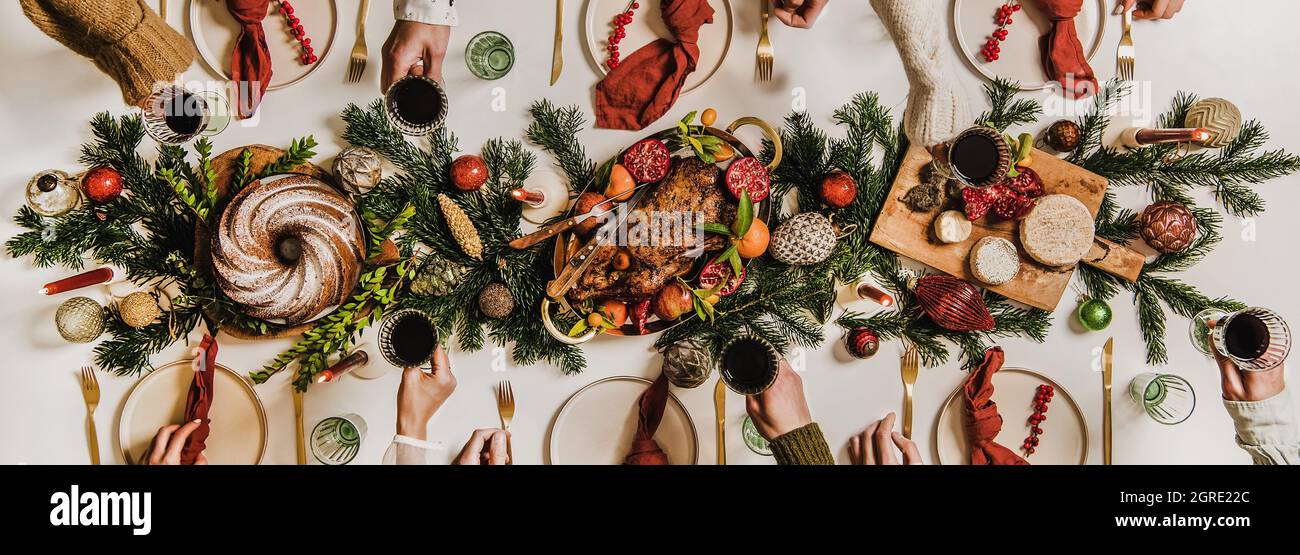 Flat-lay of Festive Christmas table setting and celebrating people hands Stock Photo