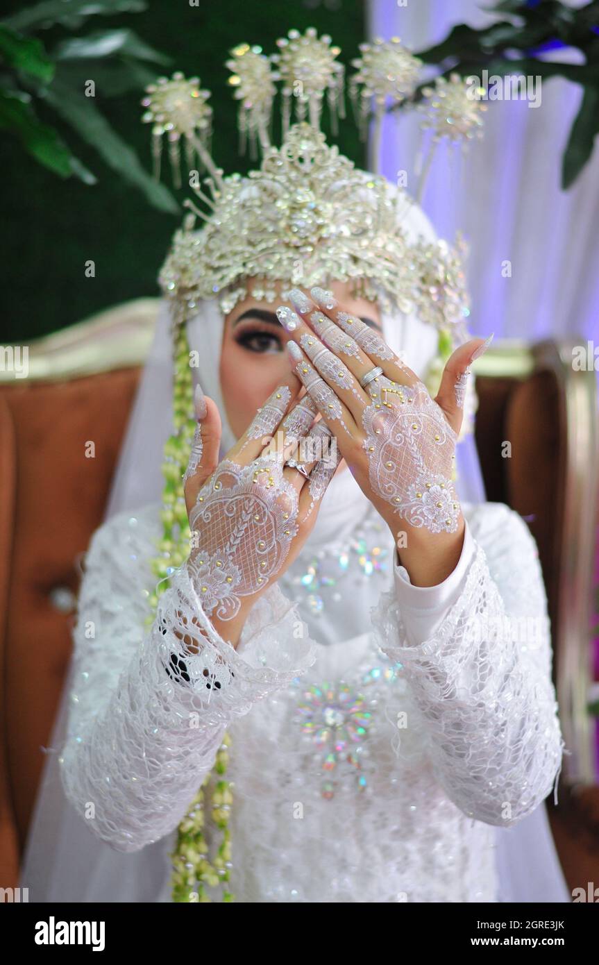 Beautiful Muslim Bride In A White Dress With A Pattern And Showing ...