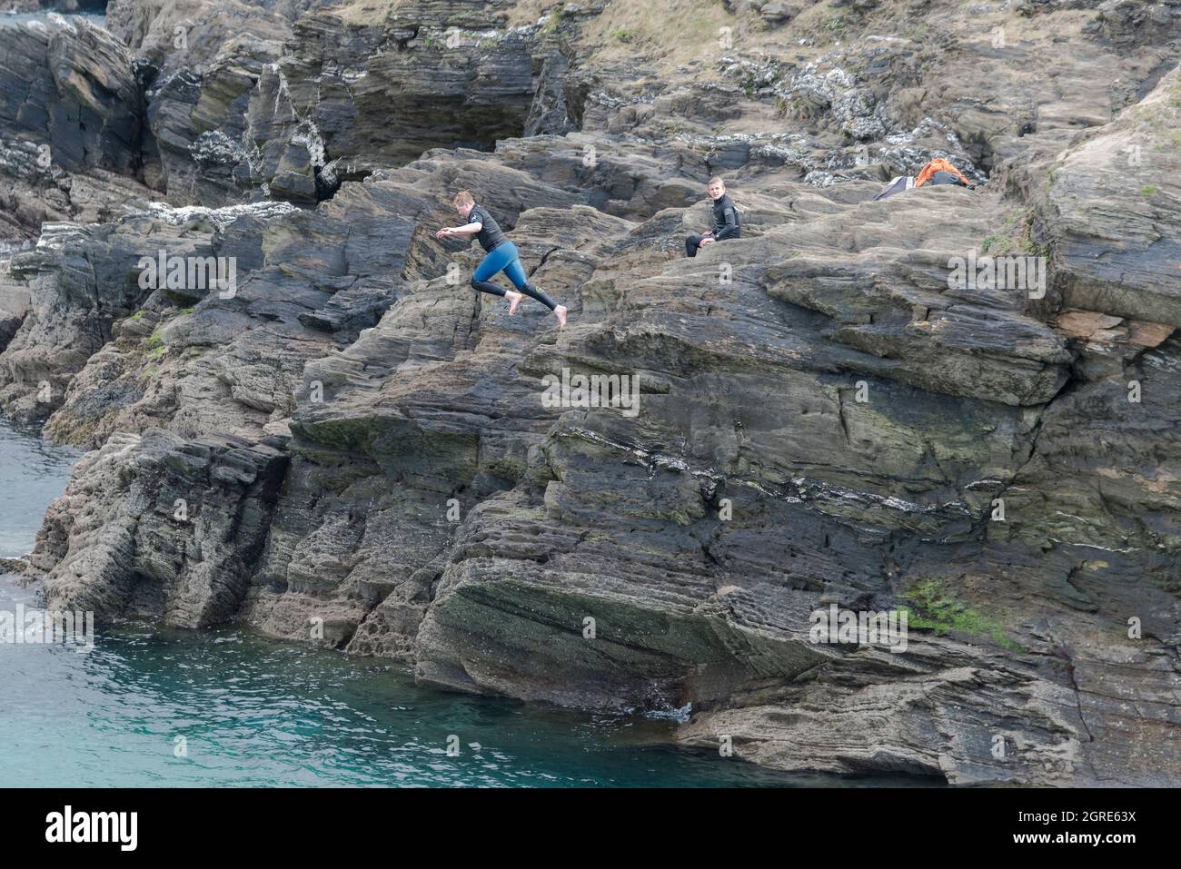 A young male teenager tombstoning off rocks on Towan Head in Newquay in Cornwall. Stock Photo