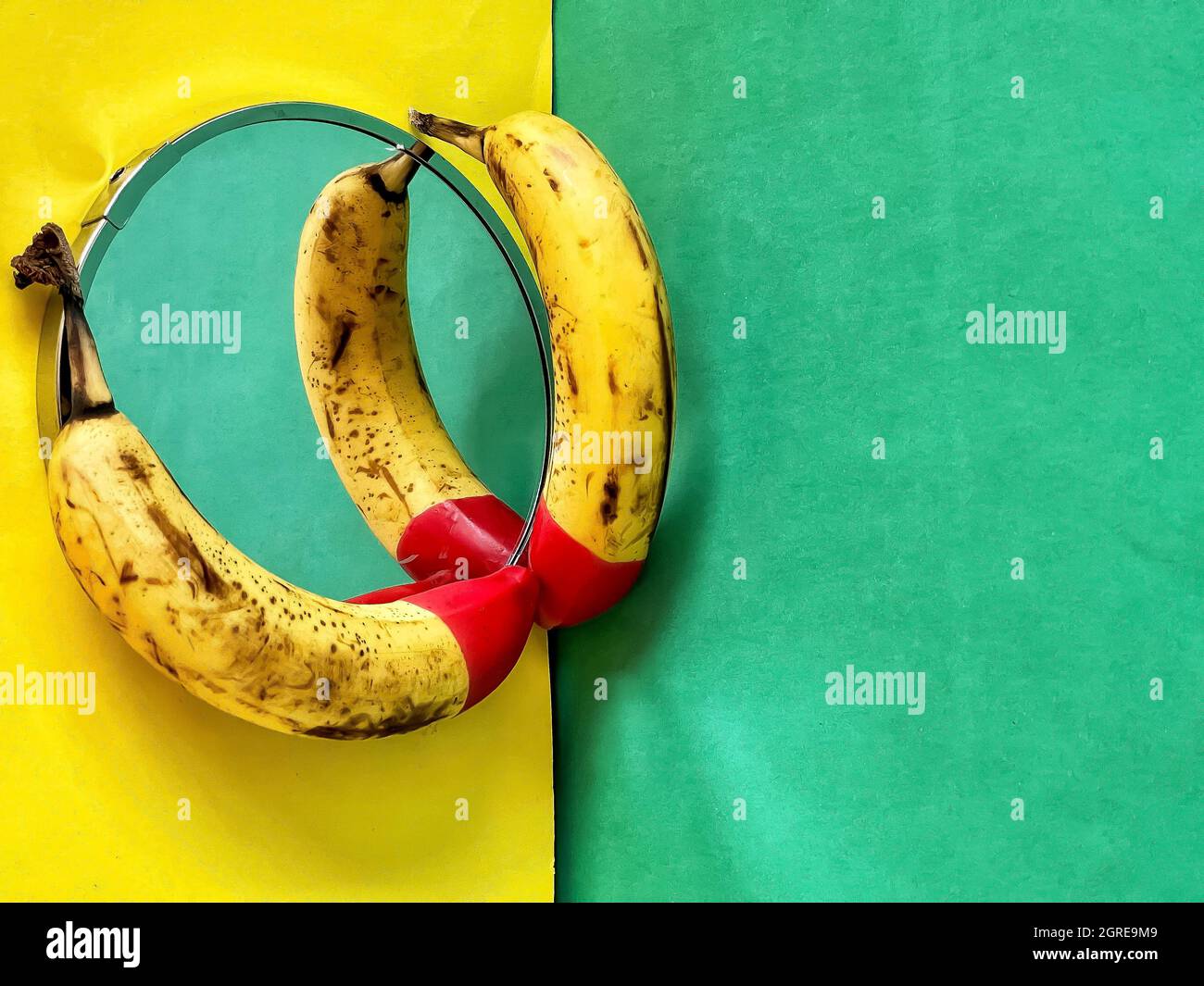 Red Tipped Bananas On Mirror On Yellow And Green Background Stock Photo -  Alamy