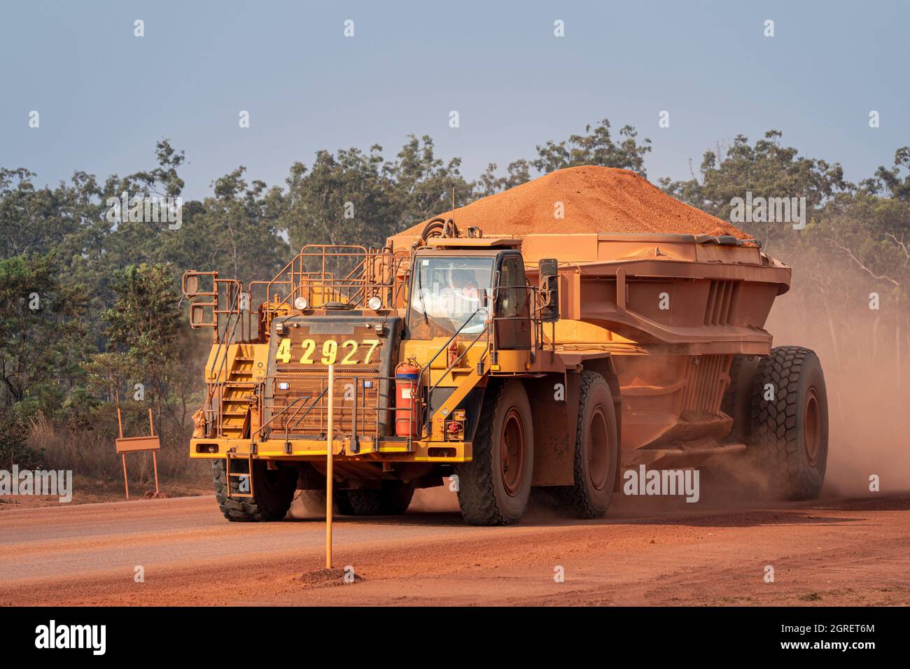 Fully loaded dump truck carrying bauxite to along haul road, Weipa