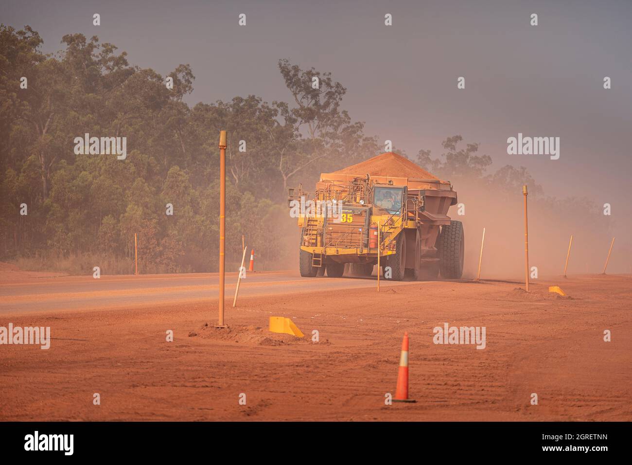 Fully loaded dump truck carrying bauxite to along haul road, Weipa