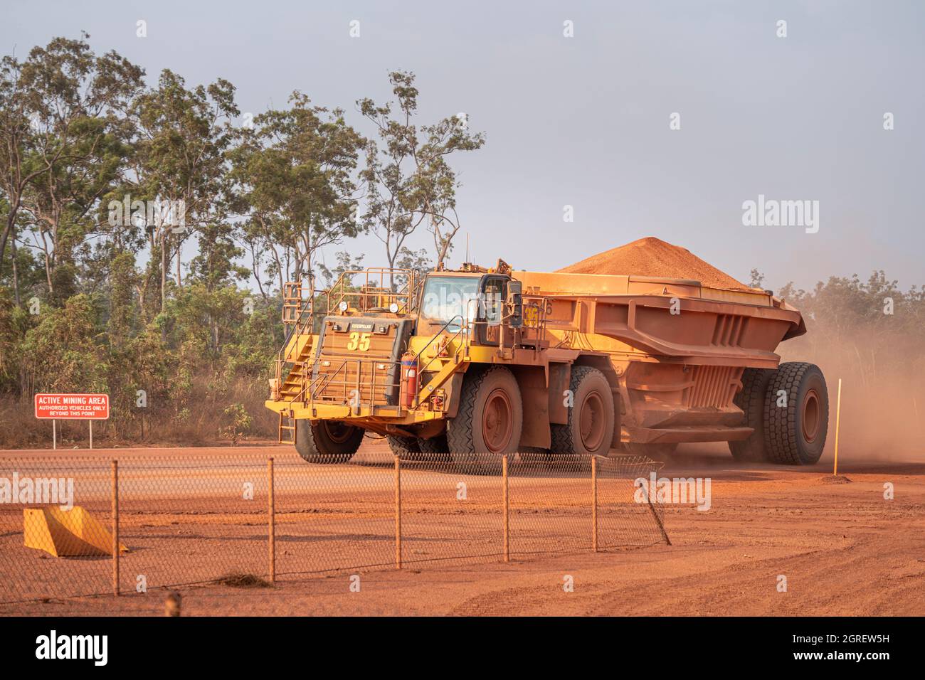 Fully loaded dump truck carrying bauxite to along haul road, Weipa
