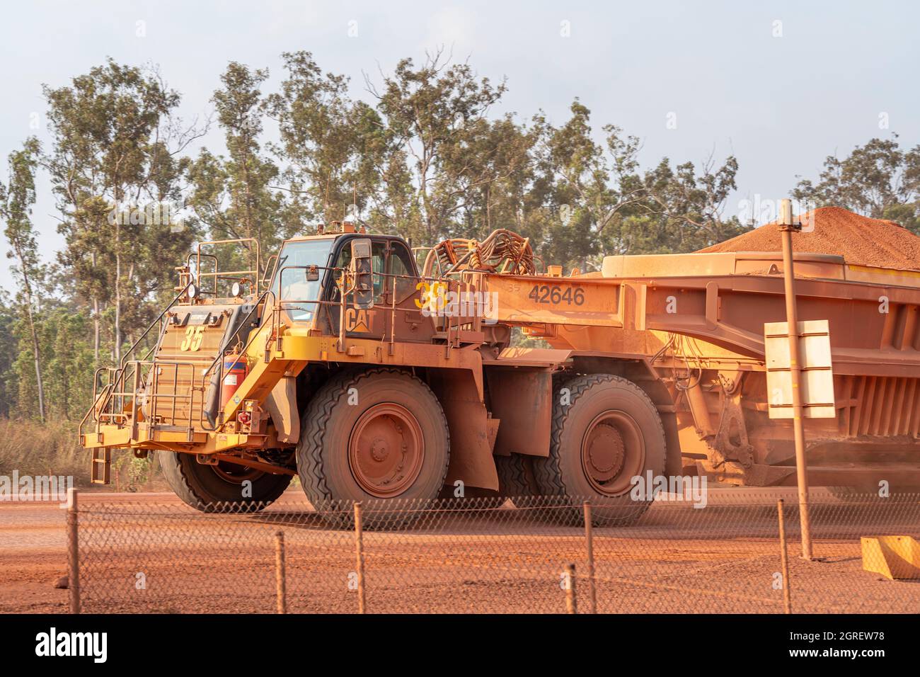 Fully loaded dump truck carrying bauxite to along haul road, Weipa