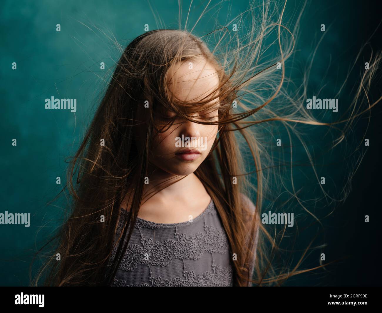 Girl With Tousled Hair Standing Against Wall Stock Photo Alamy