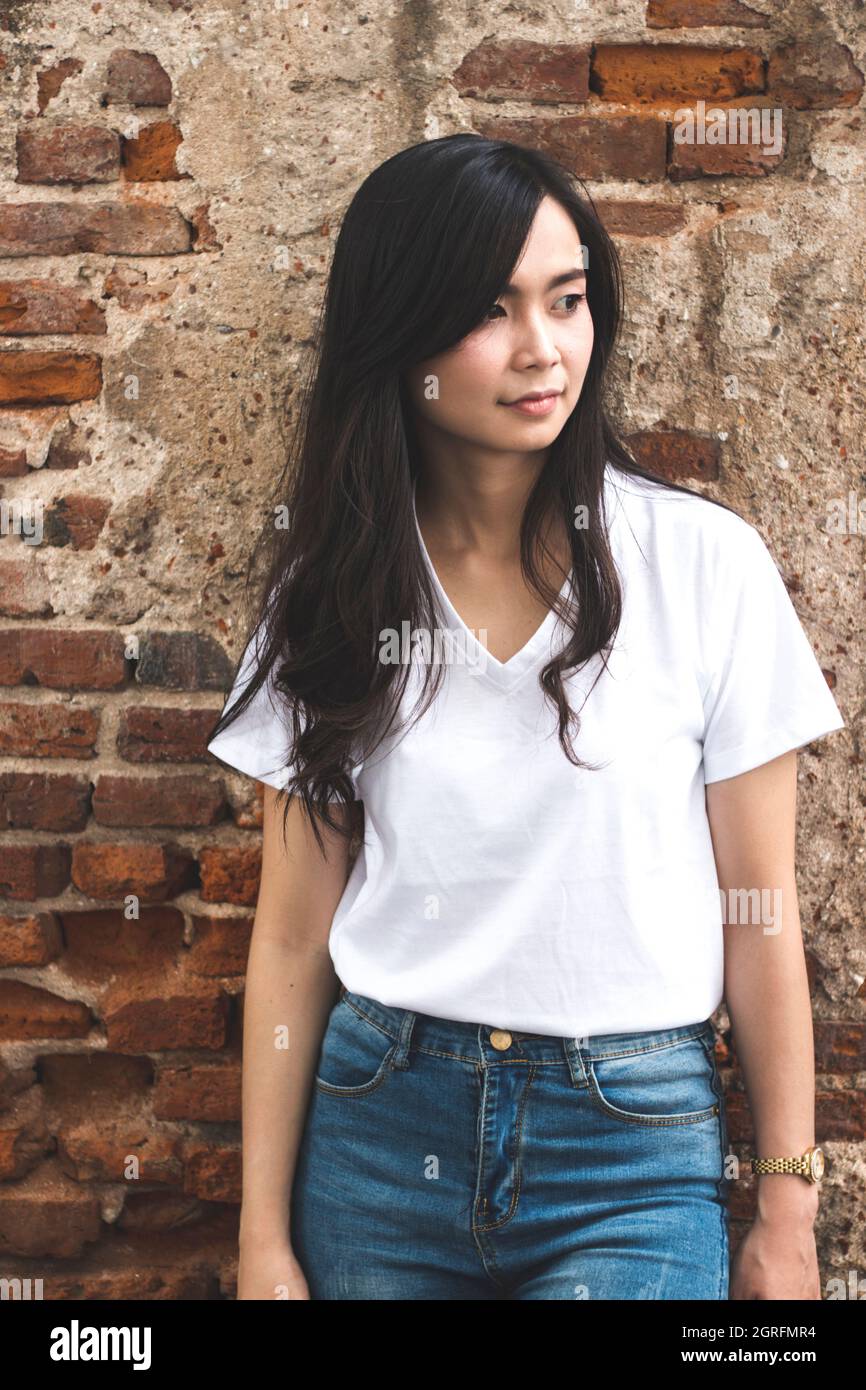 Beautiful Young Woman Standing Against Brick Wall Stock Photo - Alamy