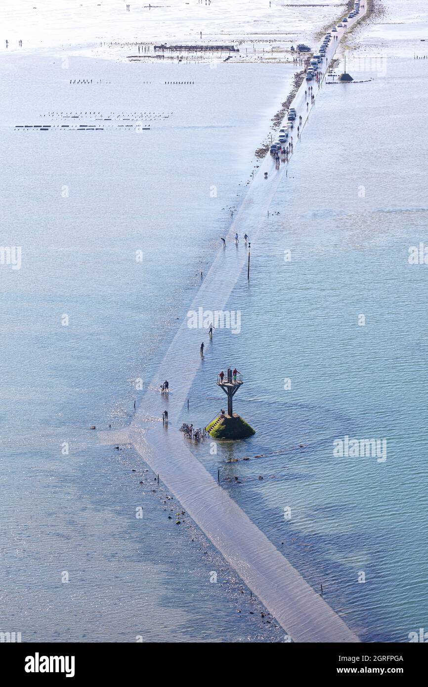 France, Vendee, Beauvoir sur Mer, safety mast (mat de perroquet) and cyclists on the passage du Gois, submersible road between Noirmoutier island and the continent (aerial view) Stock Photo