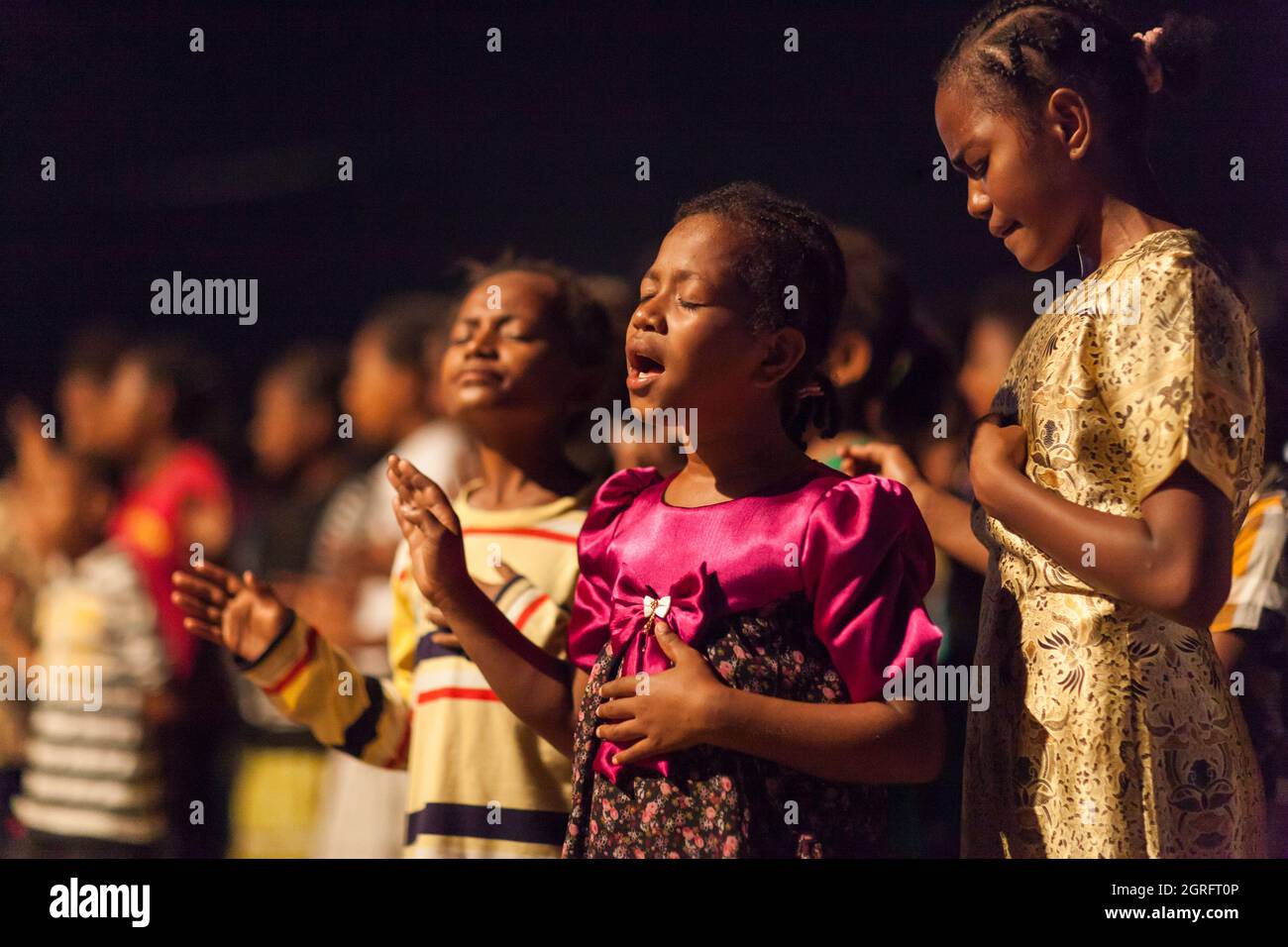 Indonesia, Papua, town of Sentani, evangelical mass, young girls praying Stock Photo