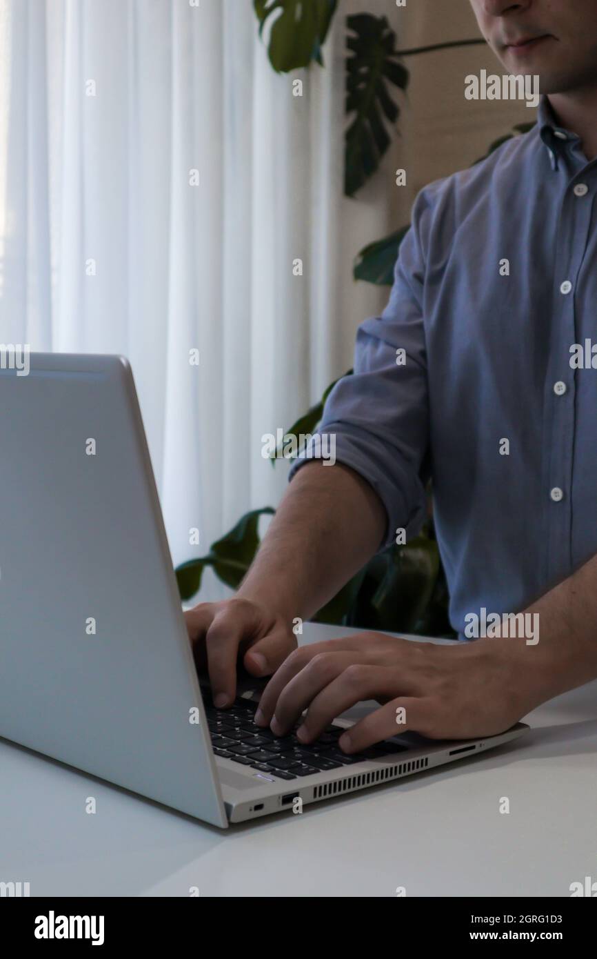 Young man is working on laptop. Frelance job. Work from home minimalism interior Stock Photo