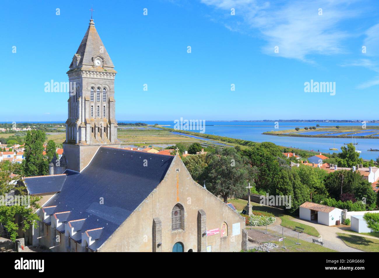 France, Vendee, Noirmoutier island, Noirmoutier en l'ile, Saint Philbert church and salt marshes in the background Stock Photo