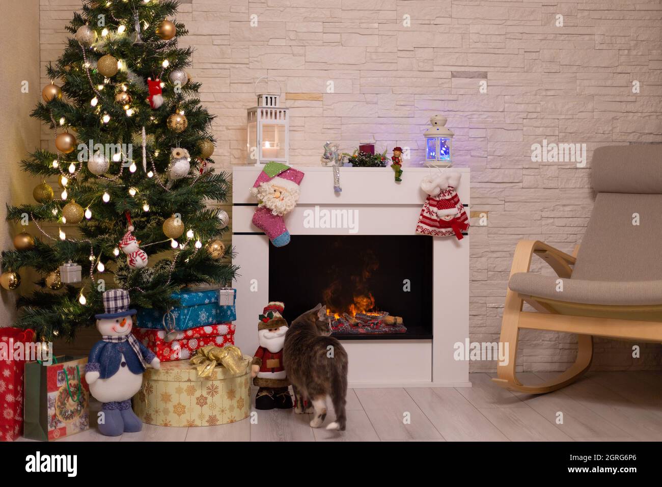 Christmas Tree With Gifts By The Fireplace For The New Year Decor Of The House 2021 2022 Stock Photo - Alamy