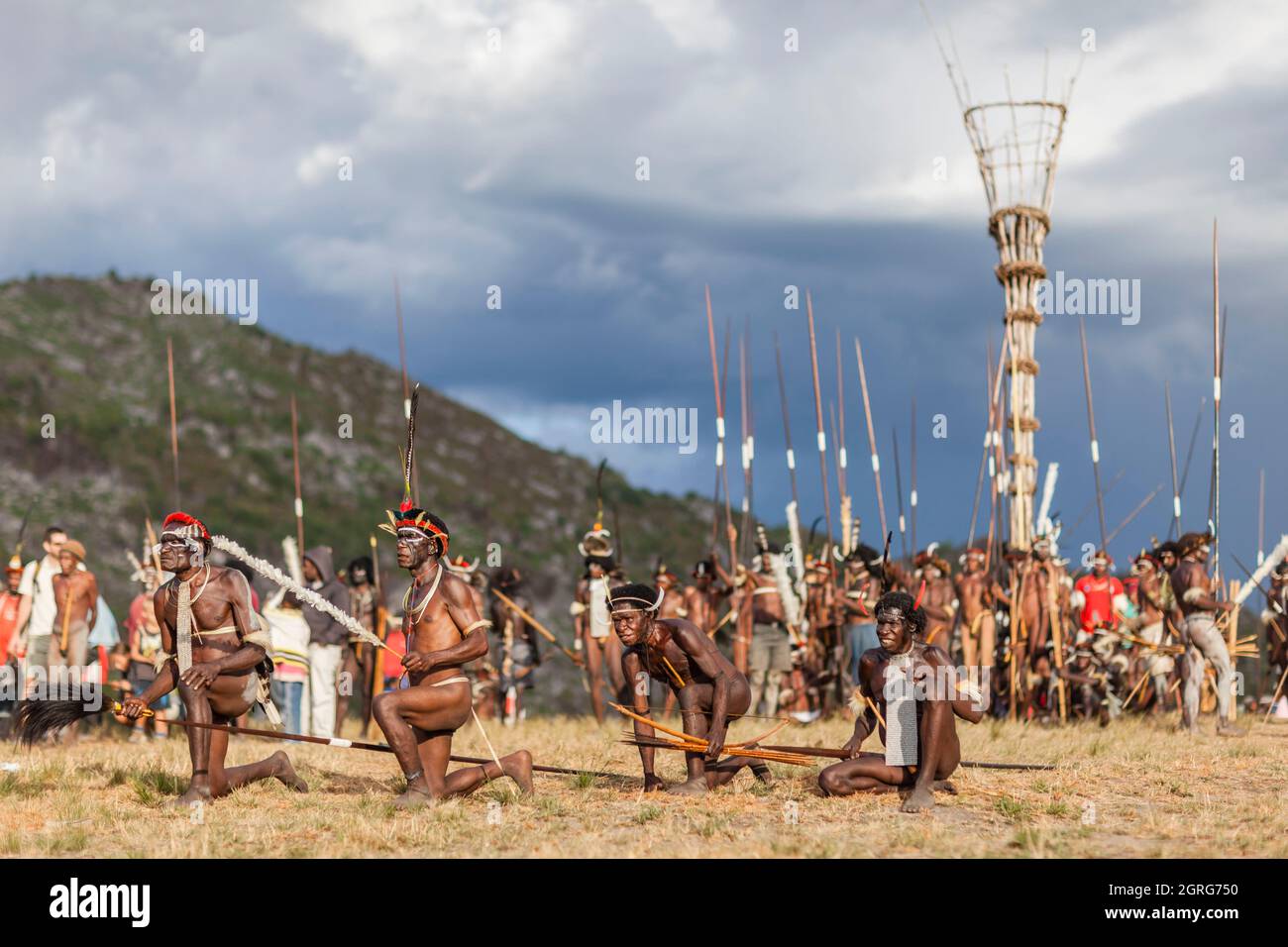 Indonesia, Papua, city of Wamena, armed members of the Dani tribe re-enacting a tribal war scene and posing in front of a watchtower. Baliem Valley Cultural Festival, every August, tribes come together to perform ancestral war scenes, parade and dance in traditional clothes Stock Photo