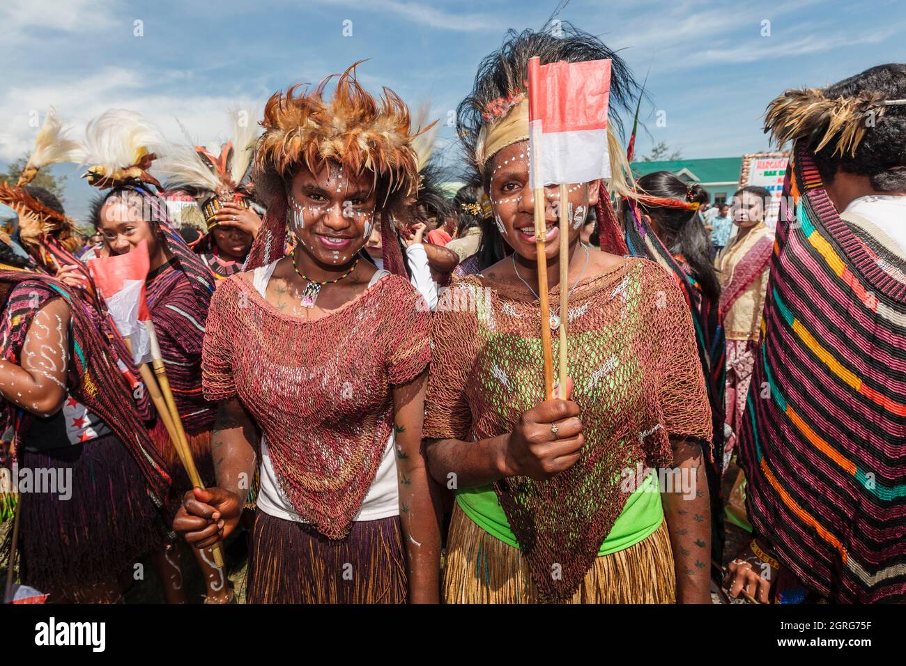 Indonesia, Papua, downtown Wamena, young women from the Dani tribe, celebration of Indonesia's Independence Day. Each tribe is invited to parade with the Indonesian flag, while showcasing its culture through traditional dances and clothes, in order to reinforce the feeling of cultural freedom. Stock Photo