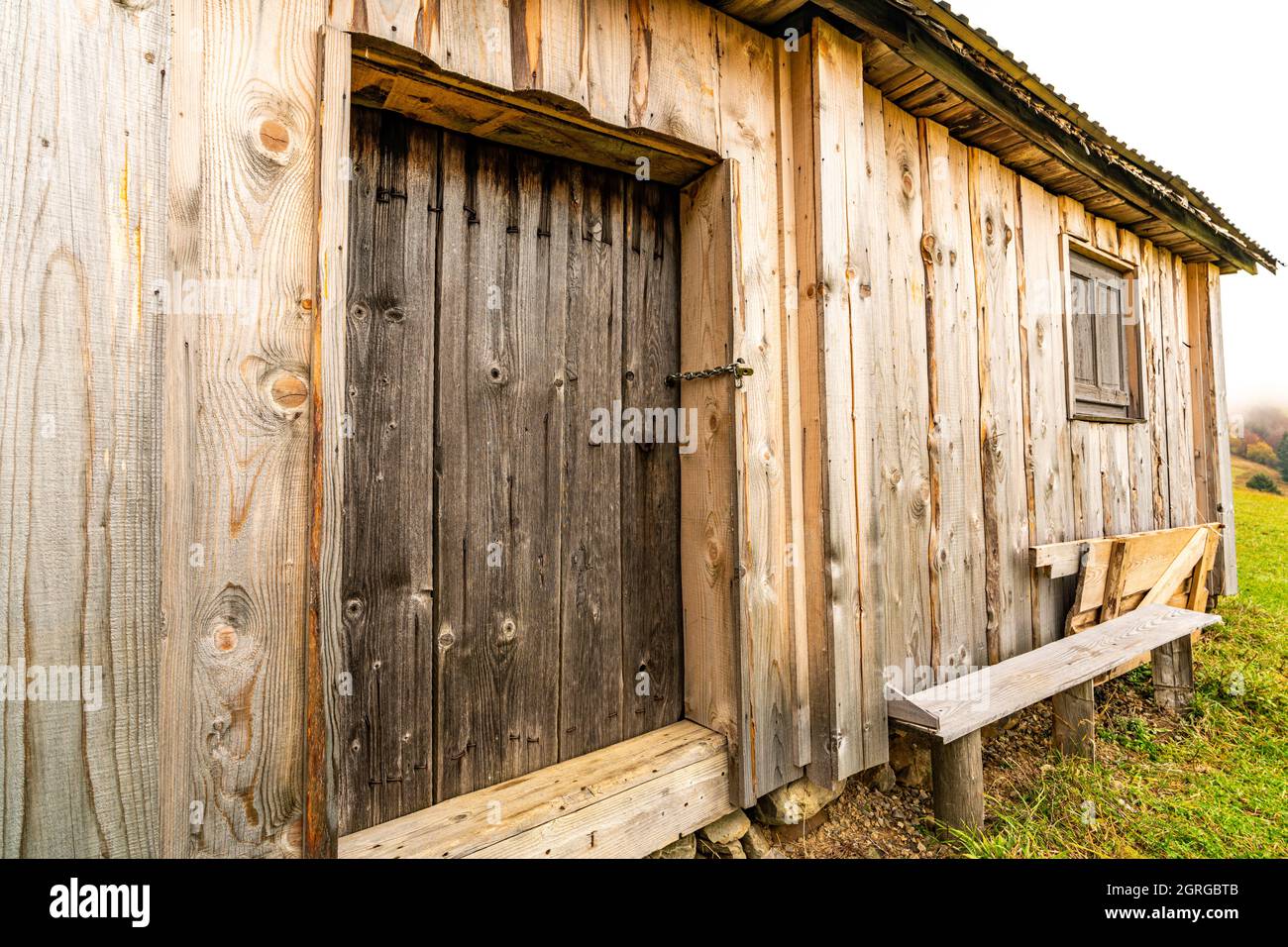 Small closed window in the wooden wall of an old house Stock Photo - Alamy