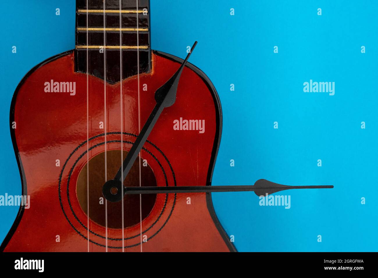 clock tongues and ukulele on blue background, close up Stock Photo