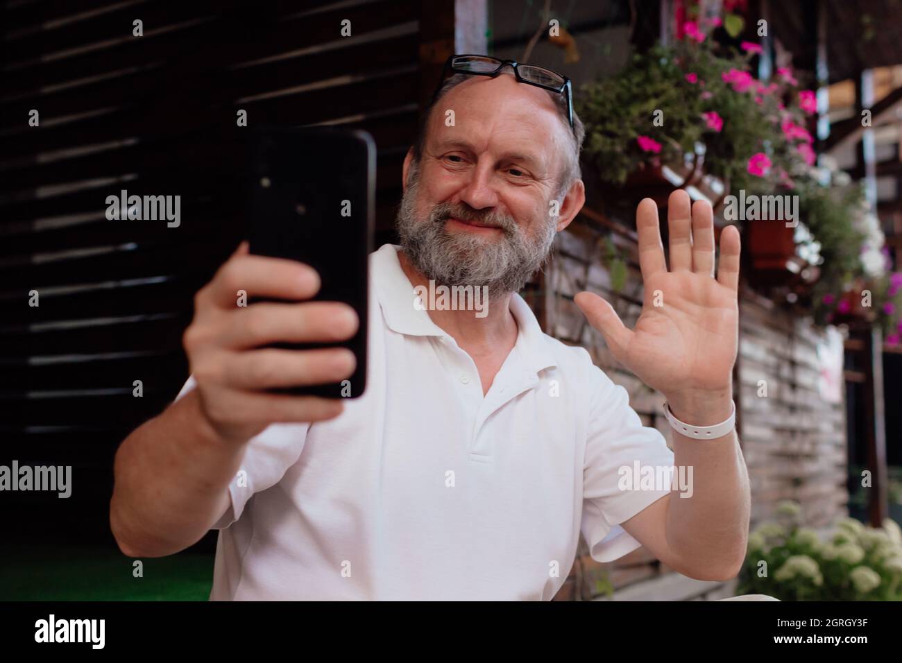 Funny old man taking selfie by smartphone. Summer holiday Stock Photo