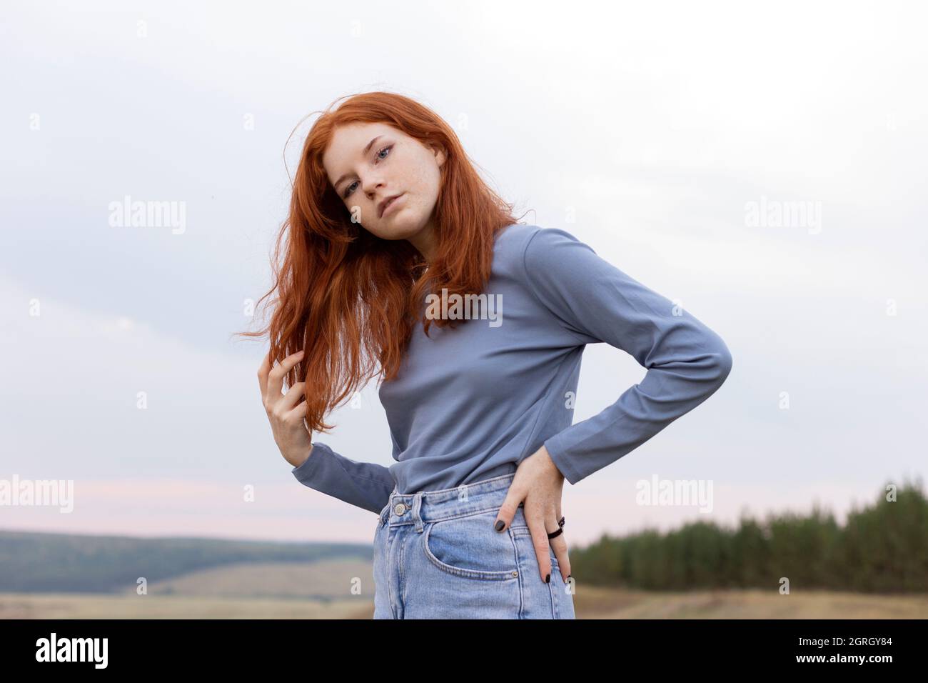 Redhead teen in the blue colour clothes in the nature Stock Photo