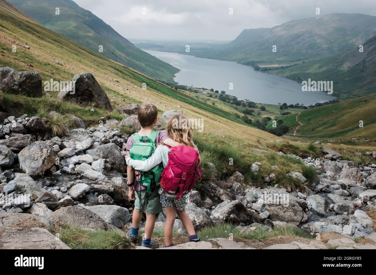 siblings hugging taking in the beautiful view over Scafell Pike Stock Photo