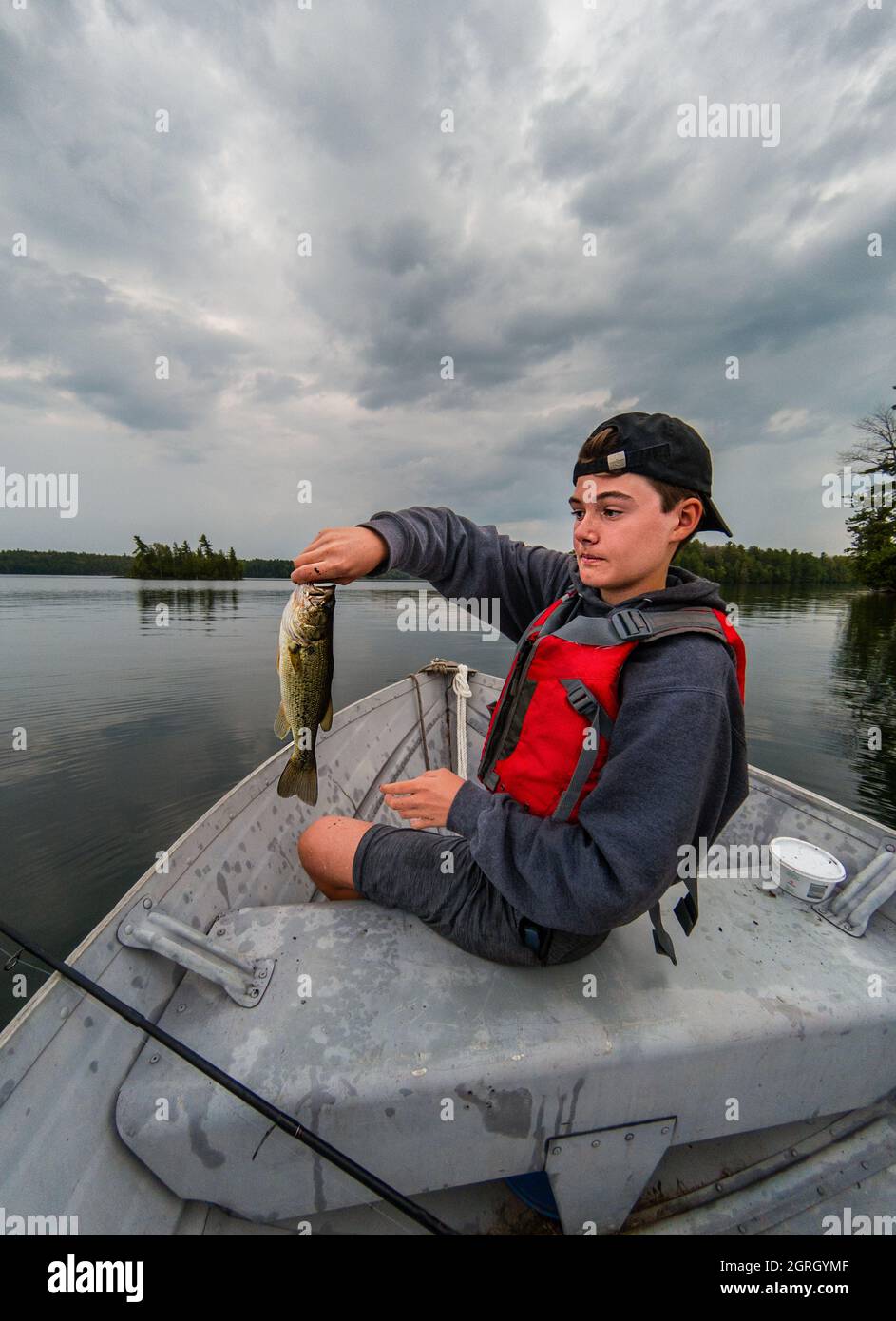Happy teen boy holding fishing hi-res stock photography and images