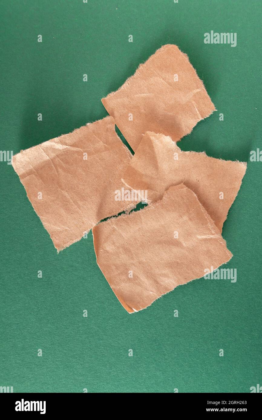 wrapping crumpled torn paper pieces against green background Stock ...