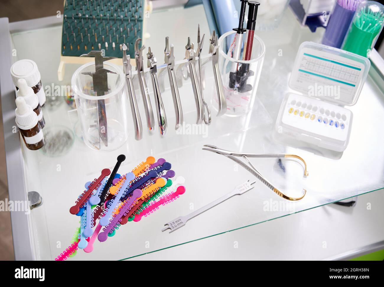 Various orthodontic tools and bracket placement card on desk in dental