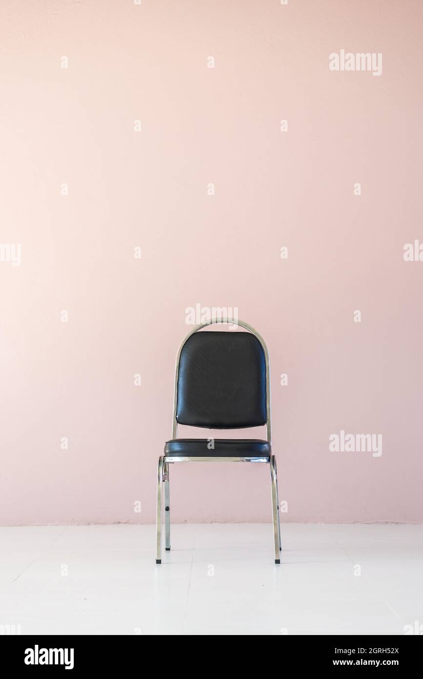 Empty Chair Against Wall Stock Photo