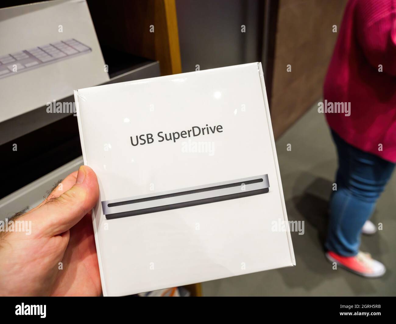 Male hand holding inside apple store almost vintage USB superDrive cd reader Stock Photo