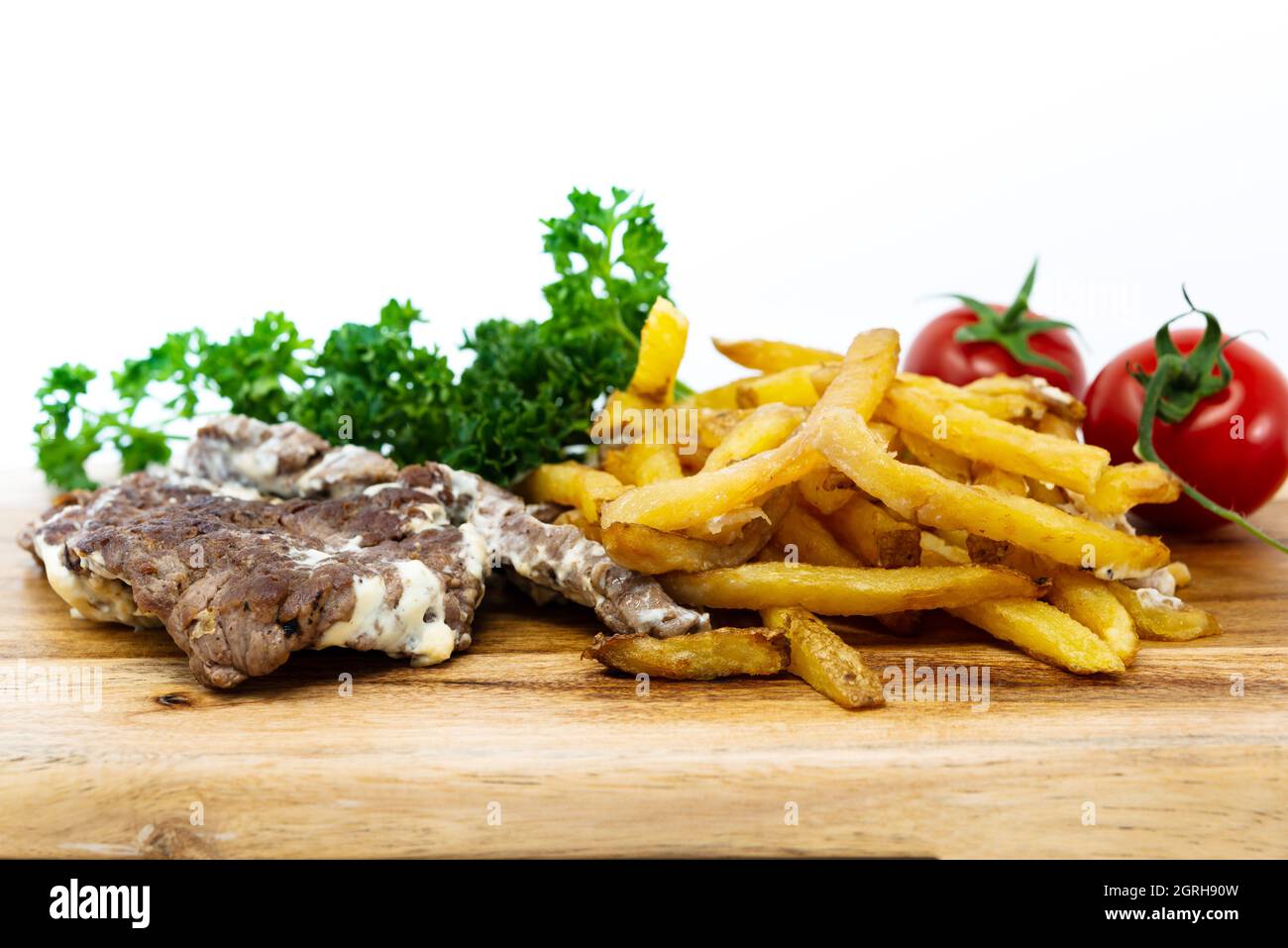 Close-up Of Meat On Cutting Board Against White Background Stock Photo