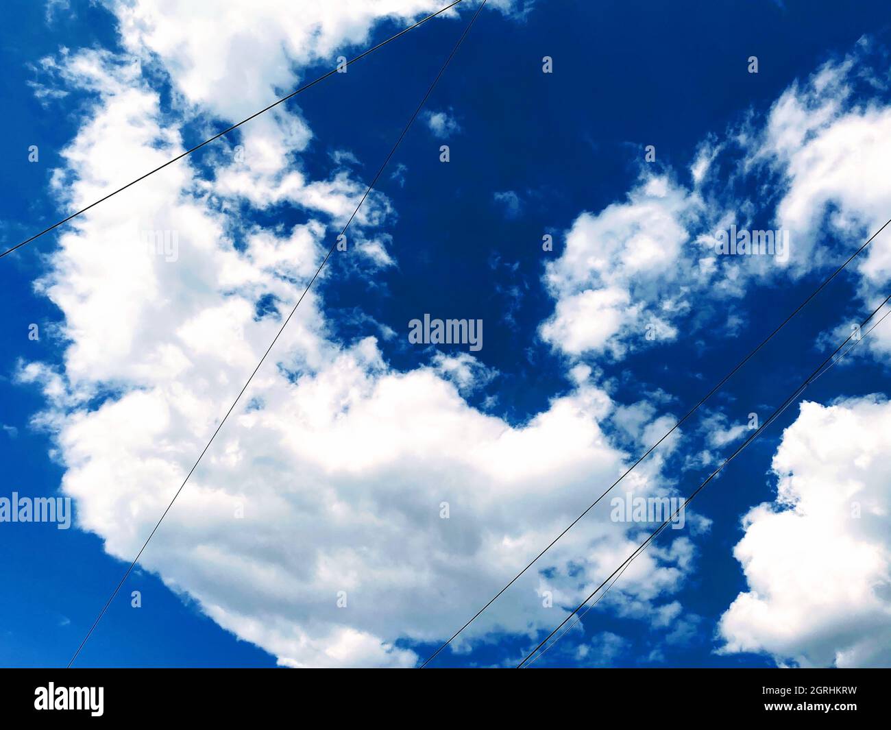Low angle shot of the white fluffy clouds in the blue daylight sky ...