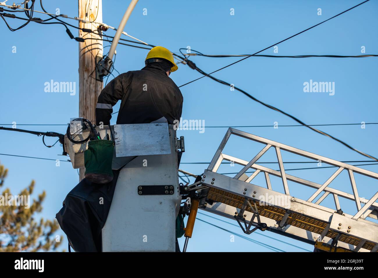 A back view of an electrical engineer sitting on a platform attached
