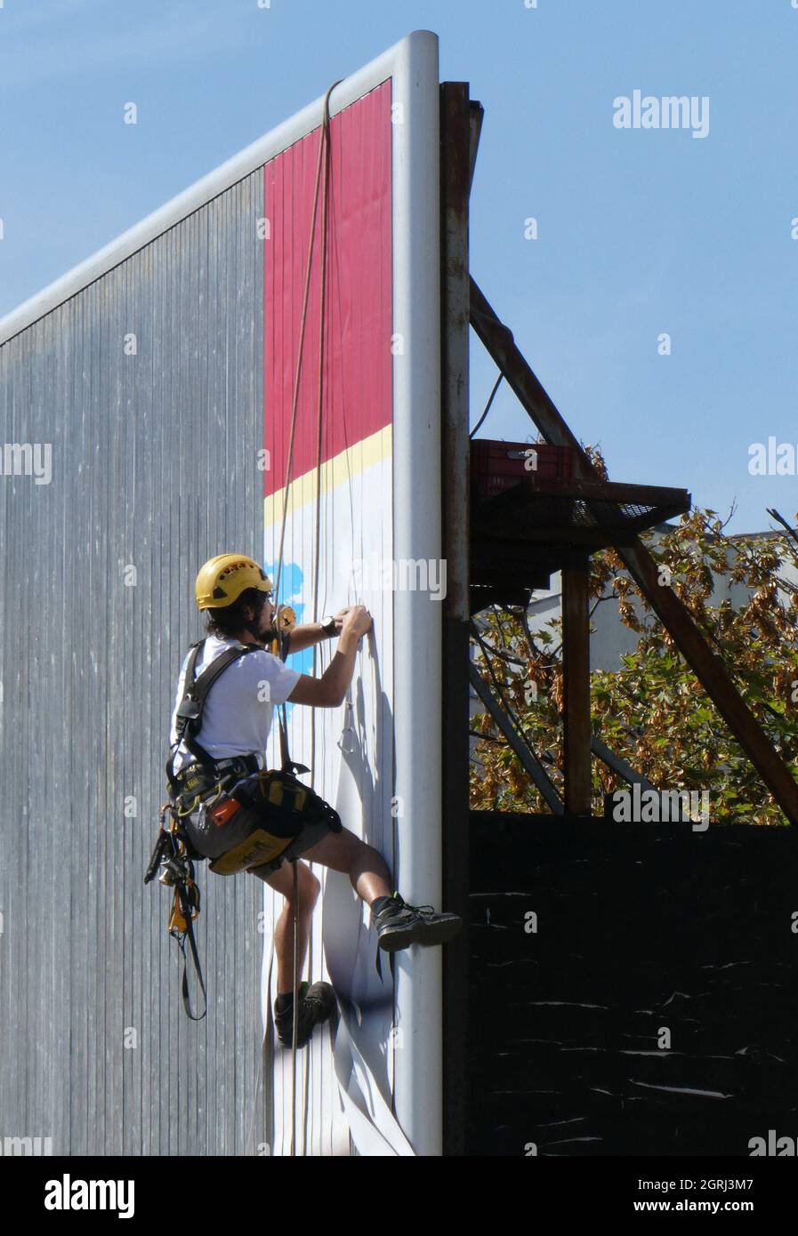 NOVI SAD, SERBIA - Sep 08, 2021: A vertical shot of a worker changing an advertisement on a billboard in Novi Sad, Serbia Stock Photo