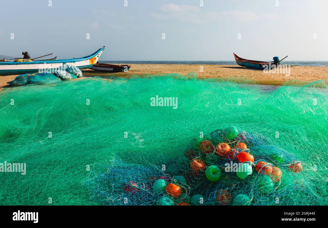 Colorful fishing net with floaters on sandy beach under sunny