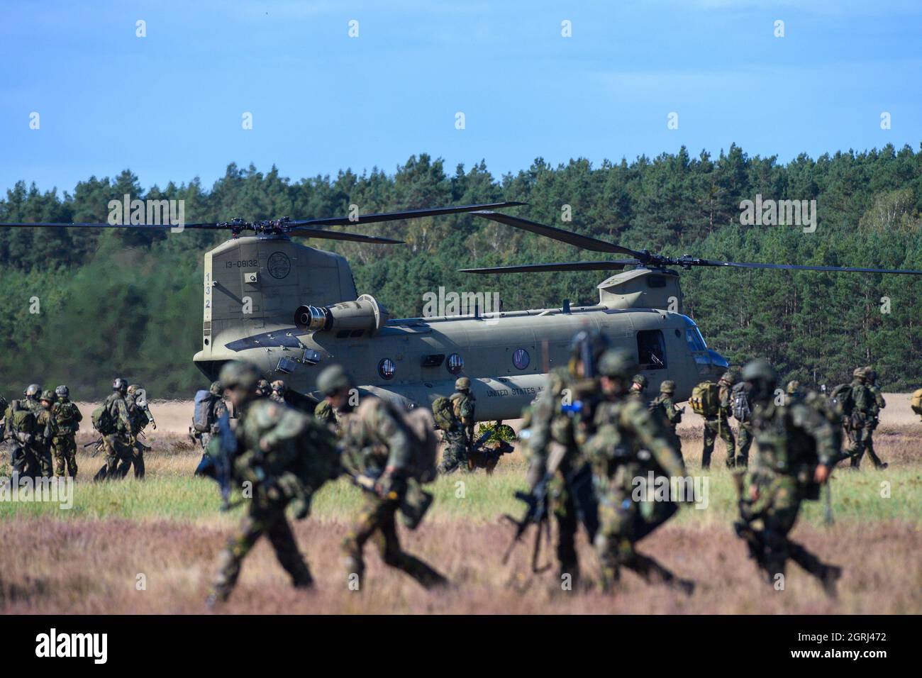 01 October 2021, Saxony-Anhalt, Klietz: Soldiers of the Falschirmjäger Regiment 26 belonging to the 'Division Schnelle Kräfte' (DSK) leave a Chinook C-47 helicopter of the U.S. Army, while other Falschirmjäger enter the helicopter. With the exercise 'Green Griffin 21', the DSK has been training combat operations within the framework of national and alliance defense since 27 September 2021 at the military training areas in Klietz, Altengrabow, Lehnin and Stendal and at the Training and Exercise Center Air Mobility in Celle. In addition to the German paratroopers, Dutch soldiers and troops from Stock Photo